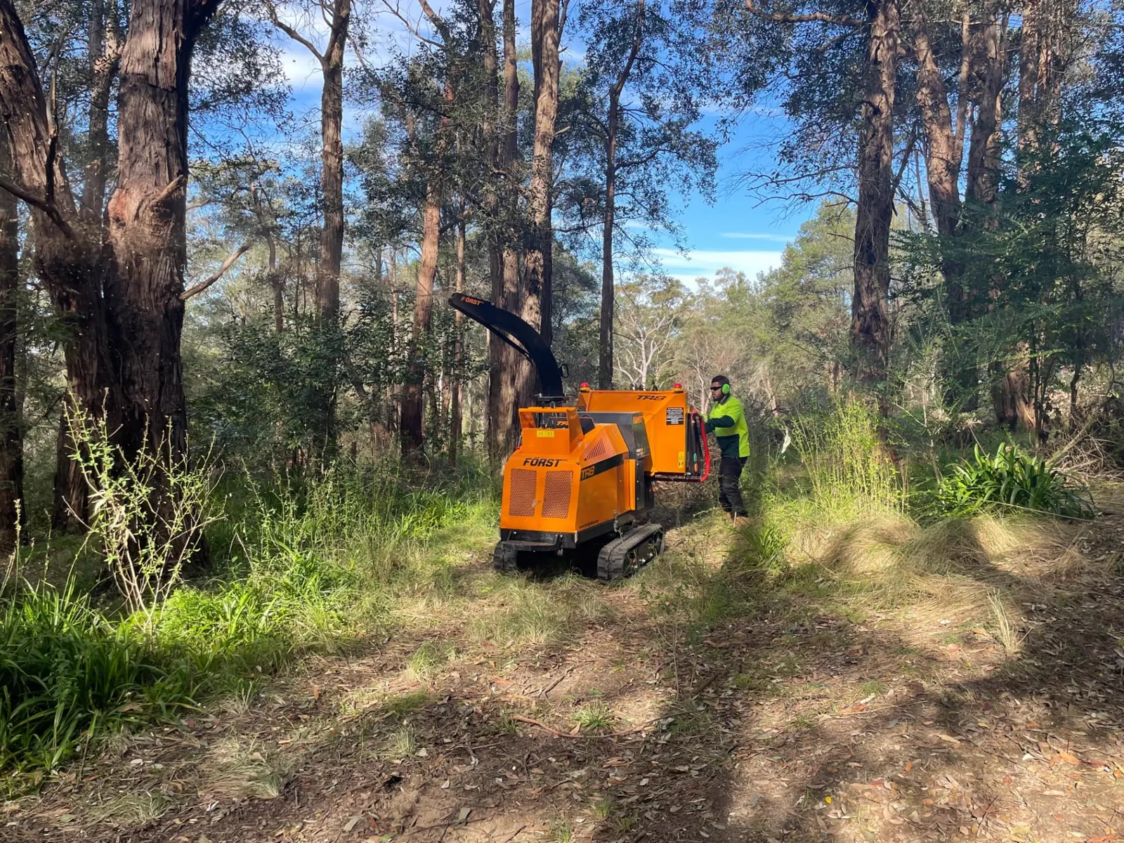 Tracked wood chipper being operated on a bush track